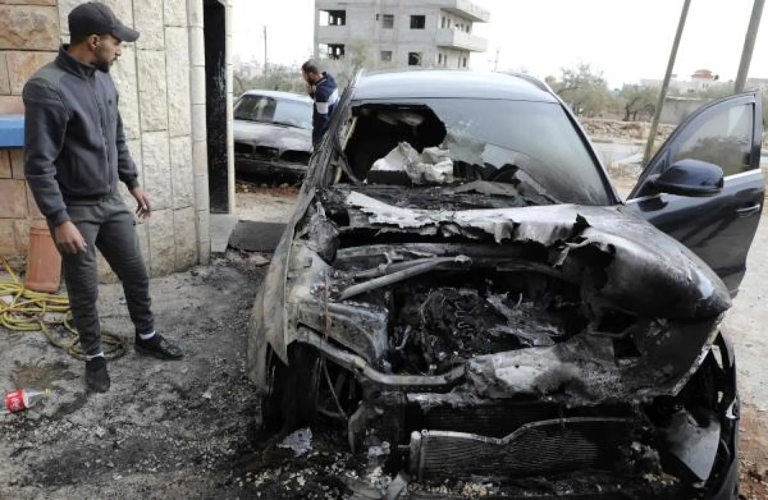A Palestinian man checks burnt cars in the village of Majdal Bani Fadel, south of Nablus in the occupied West Bank, after Israeli settlers reportedly torched vehicles on November 22, 2019. (Photo by Jaafar ASHTIYEH / AFP)
