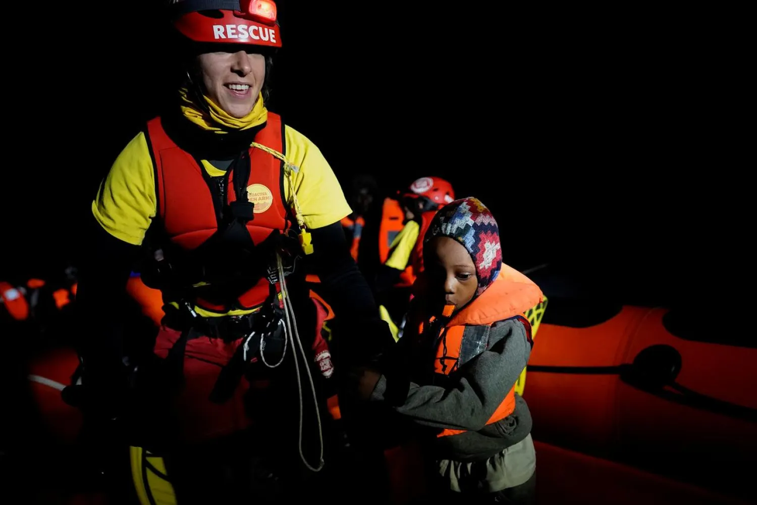 A crew member of a NGO Proactiva Open Arms rescue boat helps a child during a search and rescue (SAR) operation in the central Mediterranean Sea, November 21, 2019. REUTERS/Juan Medina