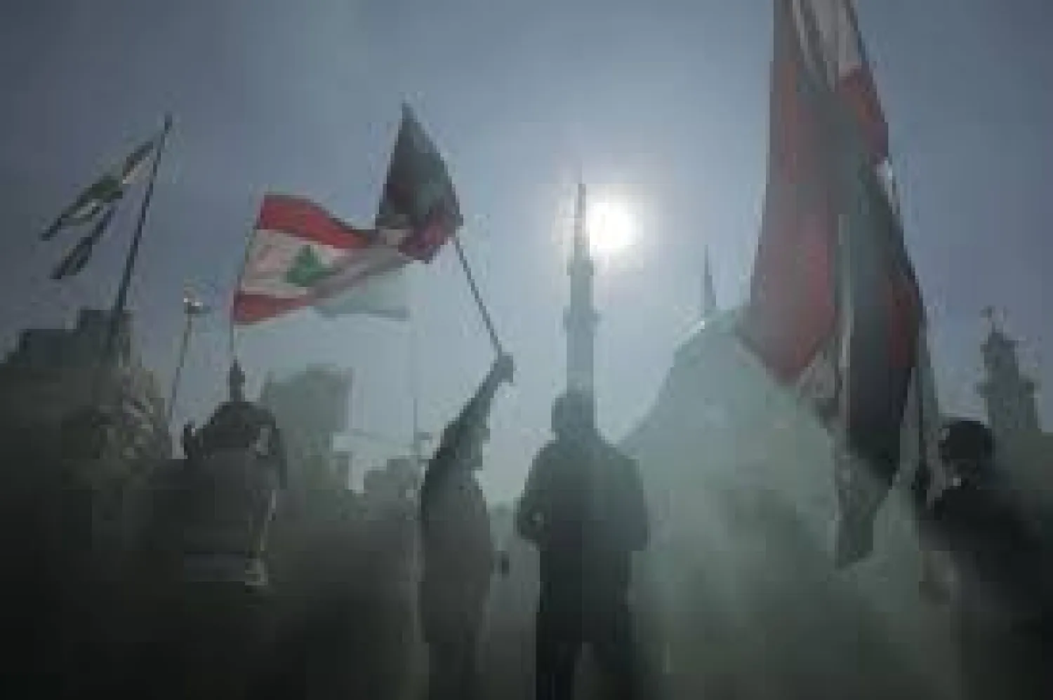 Anti-government protesters wave Lebanese national flags as gather during separate civil parade at the Martyr square, in downtown Beirut, Lebanon, Friday, Nov. 22, 2019. Protesters gathered for alternative independence celebrations, converging by early afternoon on Martyrs' Square in central Beirut, which used to be the traditional location of the official parade. Protesters have occupied the area, closing it off to traffic since mid-October. (AP Photo/Hassan Ammar)