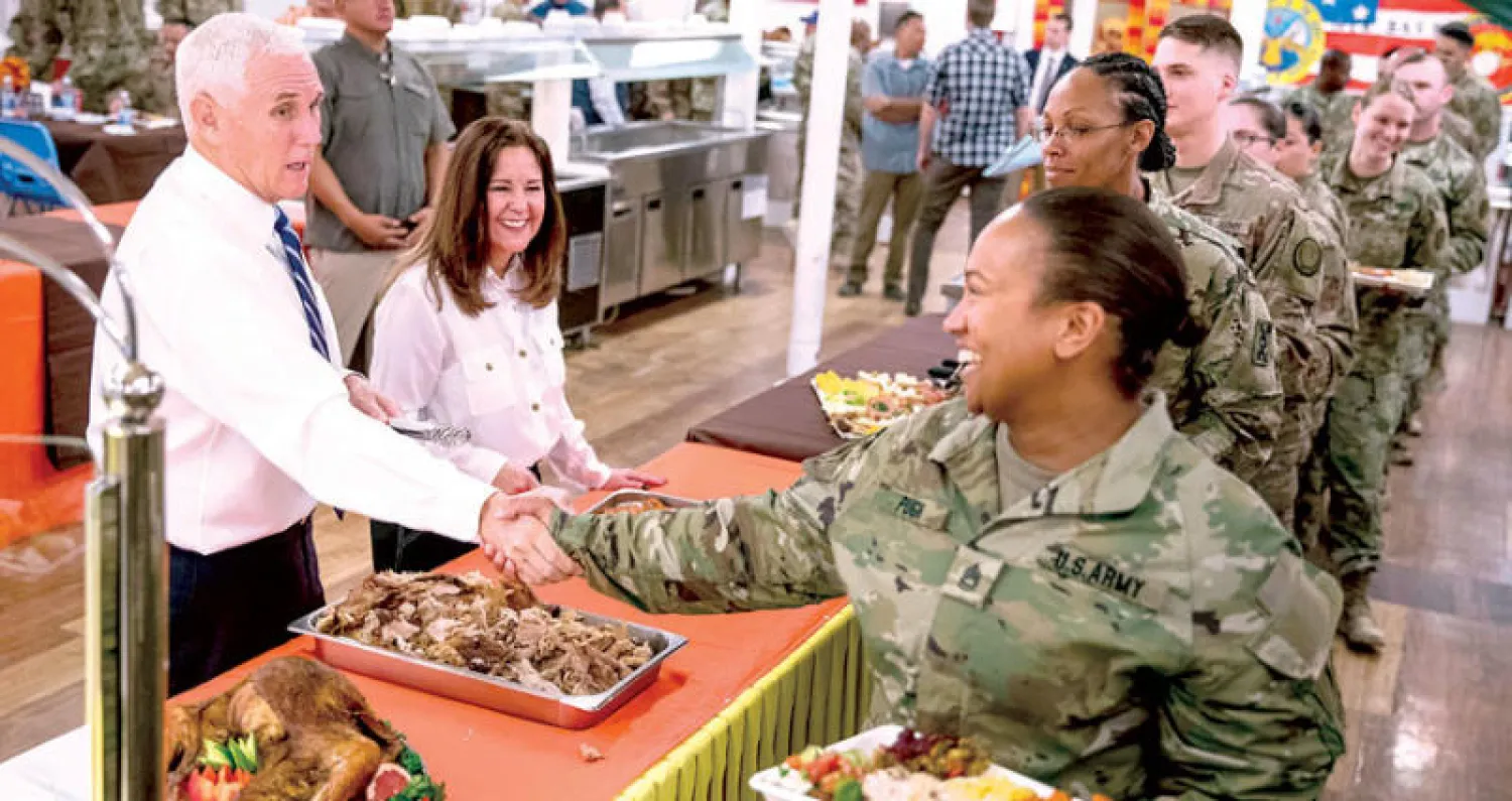 نائب الرئيس الأميركي مايك بنس وزوجته يقدمان الطعام للجنود الأميركيين في قاعدة «عين الأسد» بمحافظة الأنبار غرب العراق أمس (أ.ب)