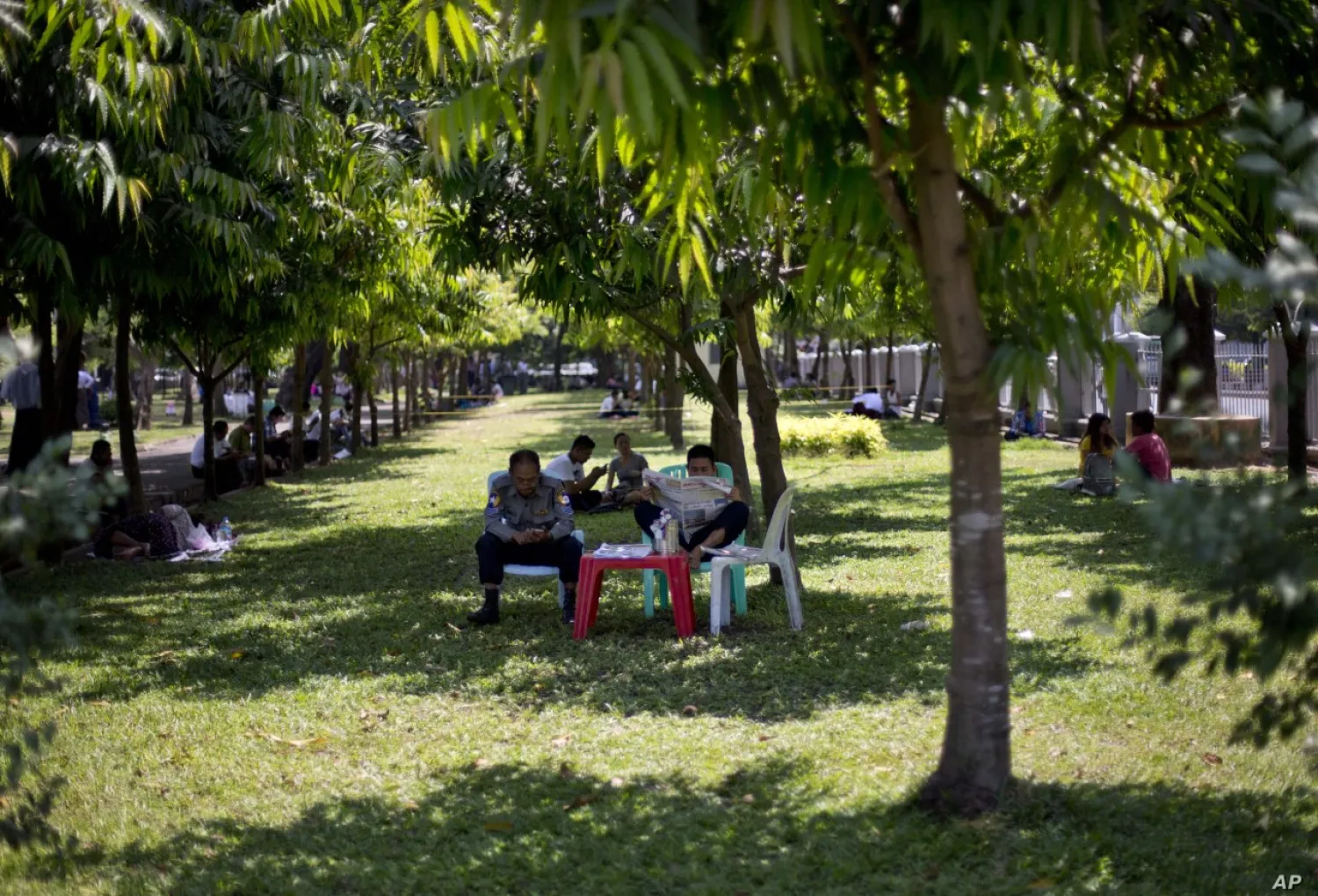 Police officers sit in the shade of a tree on a hot, humid day at a public par; in Yangon, Myanmar, March 17, 2016. AP