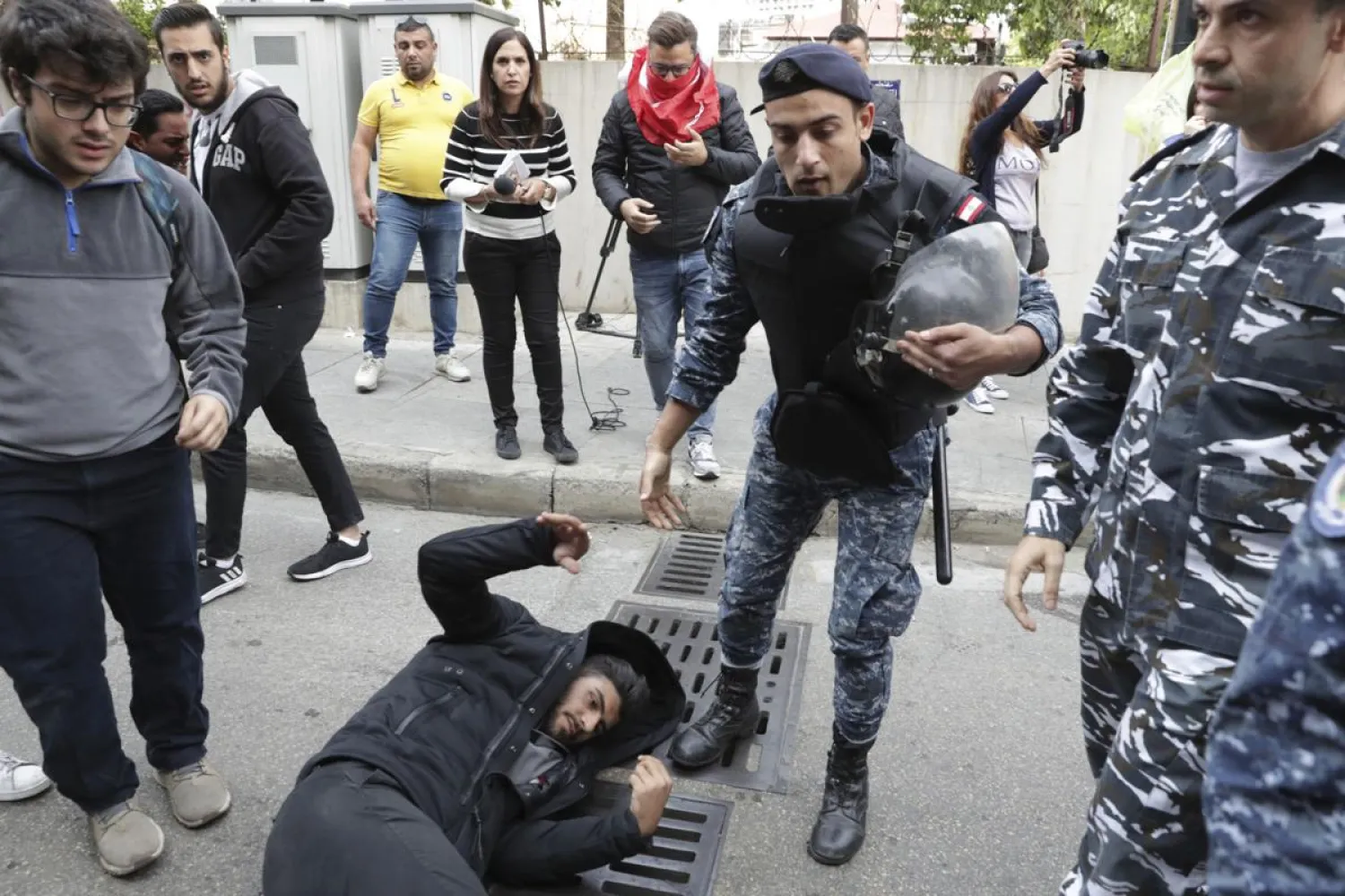 Riot police scuffle with anti-government protesters blocking a road in Beirut, Lebanon, Monday, Nov. 25, 2019. (AP Photo/Hassan Ammar)