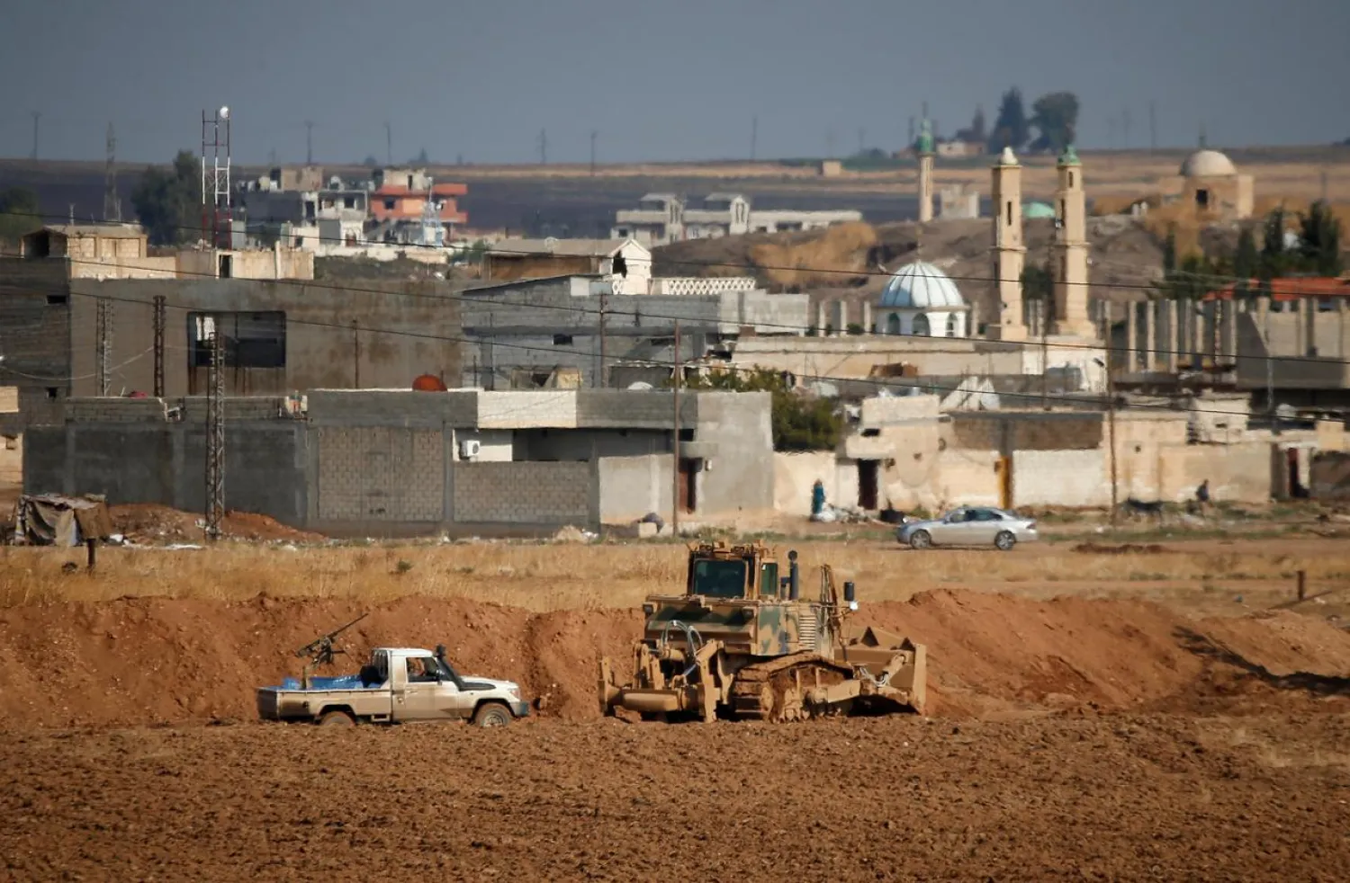 A Turkey-backed Syrian fighter walks next to their vehicle in the Syrian town of Ras al-Ain, as seen from the Turkish border town of Ceylanpinar, in Sanliurfa province, Turkey, October 30, 2019. (Reuters)