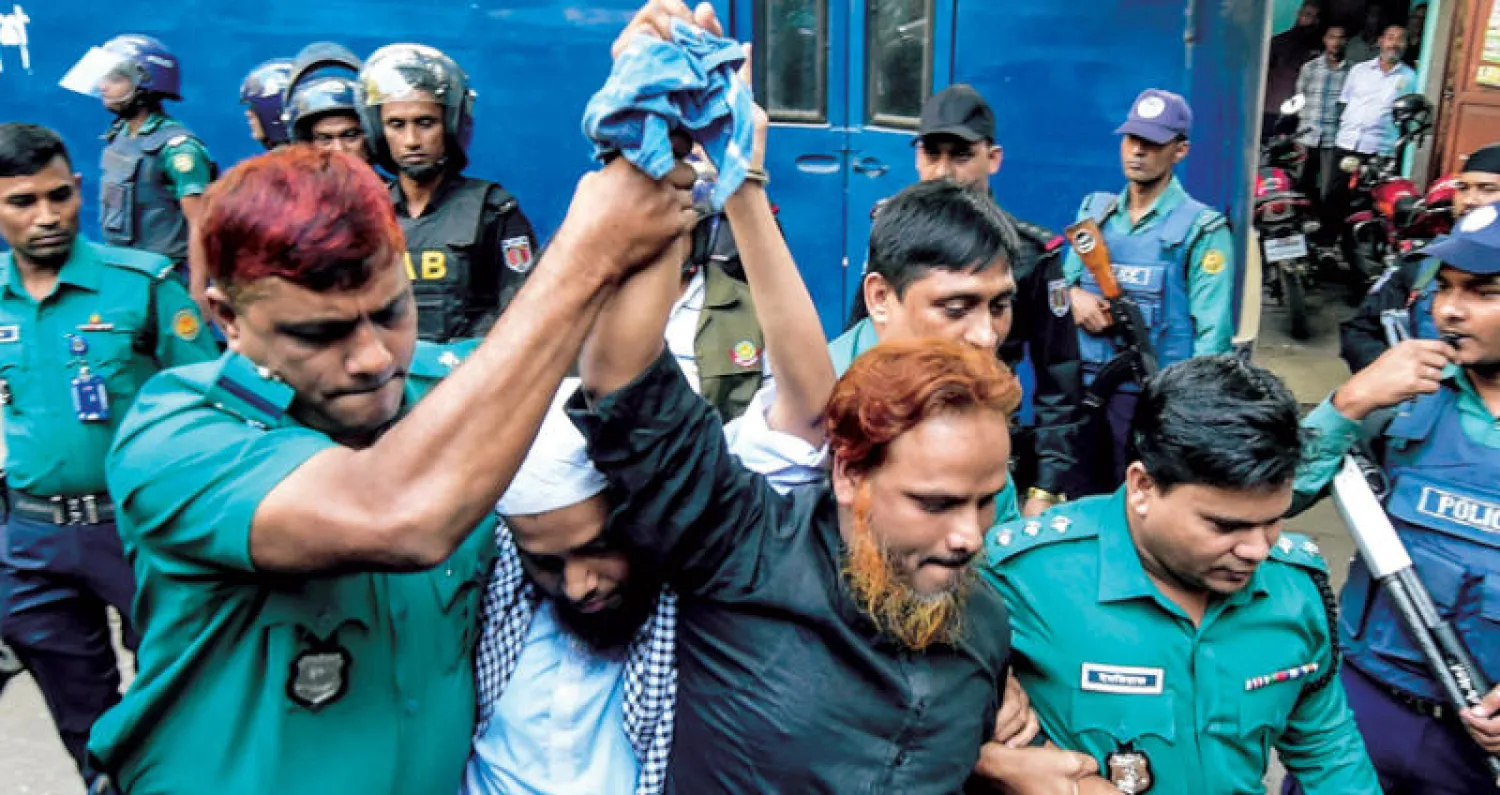 الأمن البنغلاديشي يصطحب متهمين بهجوم إرهابي إلى المحكمة في دكا أمس (أ.ف.ب)