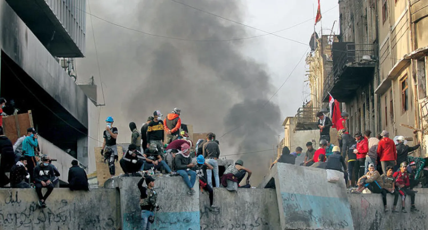 محتجون يقطعون أحد الشوارع في بغداد خلال مواجهات مع قوات مكافحة الشغب أمس (أ.ف.ب)