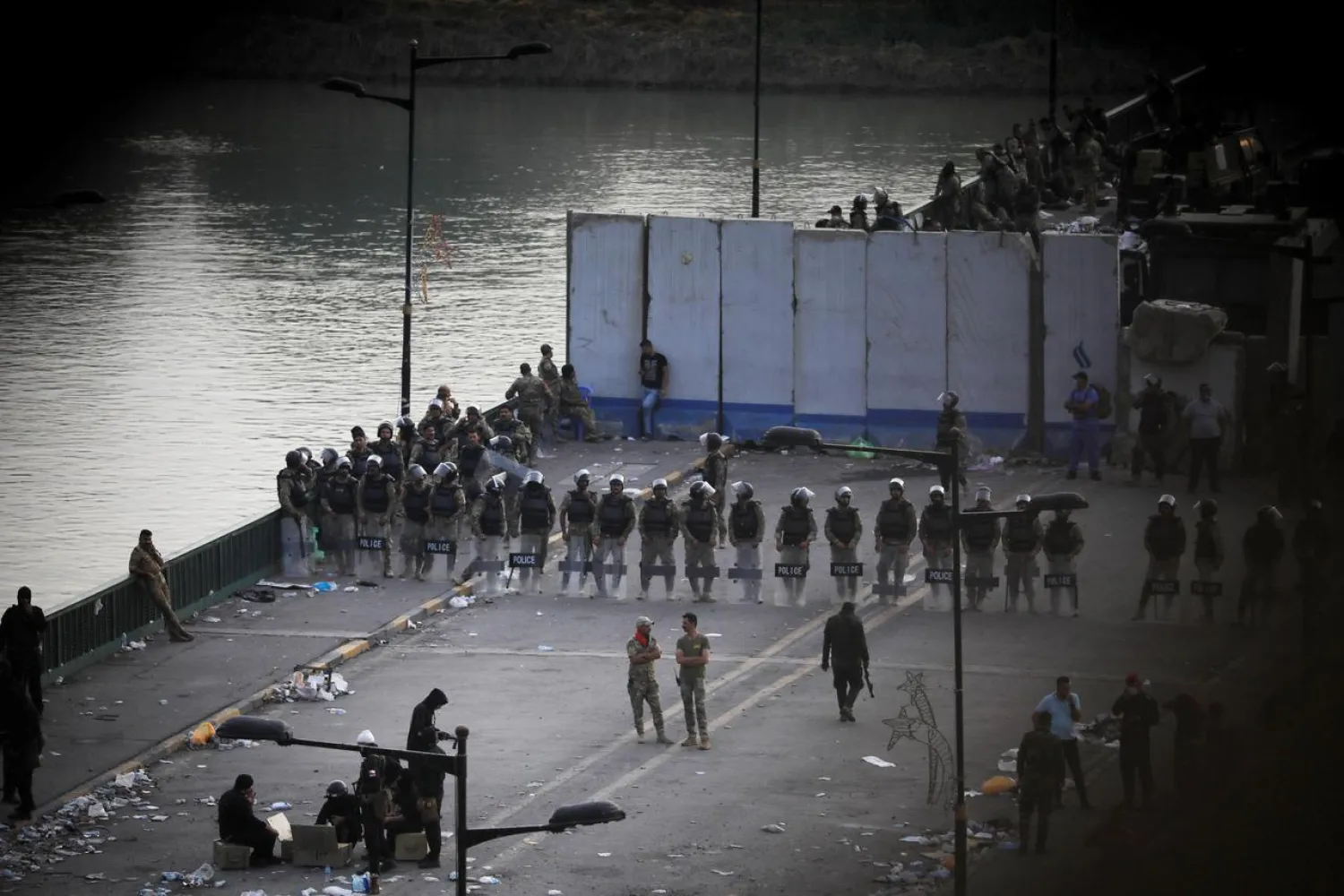FILE PHOTO: Riot police stand at Al Jumariyah Bridge during a protest over corruption, lack of jobs, and poor services, in Baghdad, Iraq October 27, 2019. REUTERS/Thaier Al-Sudani/File Photo
