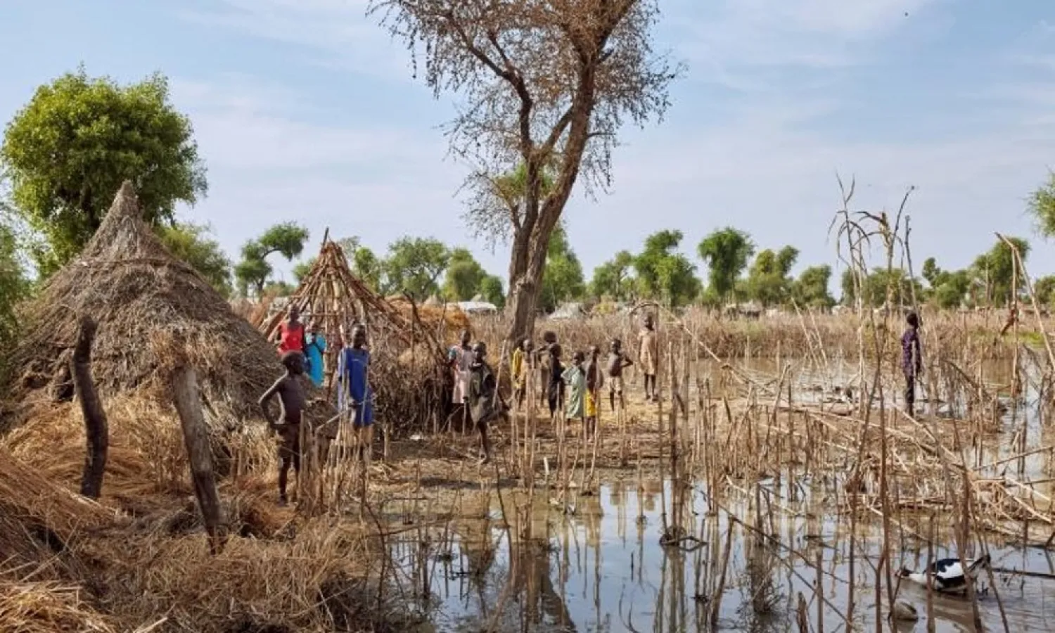 Children stand among the rooftops of homes after the Yusuf Batir refugee camp in South Sudan was hit by flooding. (AFP)