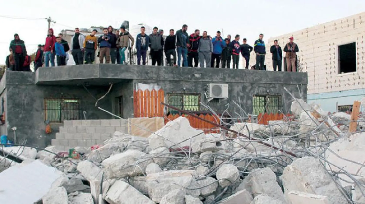 Batı Şeria'nın Deir Kahal kasabasında İsrailli bir askeri bıçakladığı için tutuklanan gençlerin aileleri yıkılmış evlerini izliyor (DPA)