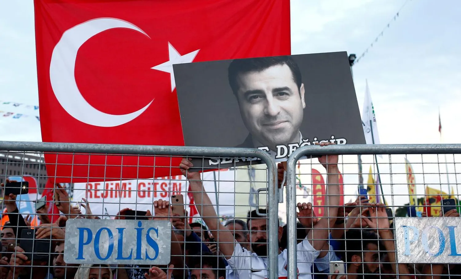 A supporter of Turkey's Peoples' Democratic Party (HDP) holds a portrait of their jailed former leader Selahattin Demirtas during a campaign event in Istanbul, Turkey, June 17, 2018. (Reuters)