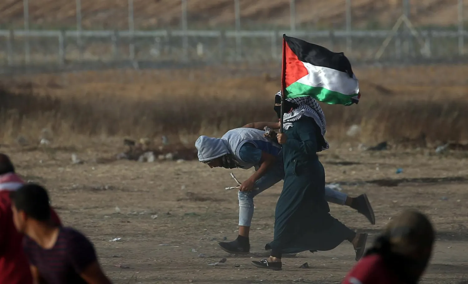 A female demonstrator runs for cover during a protest where Palestinians demand the right to return to their homeland, at the Israel-Gaza border in the southern Gaza Strip May 25, 2018. (Reuters)