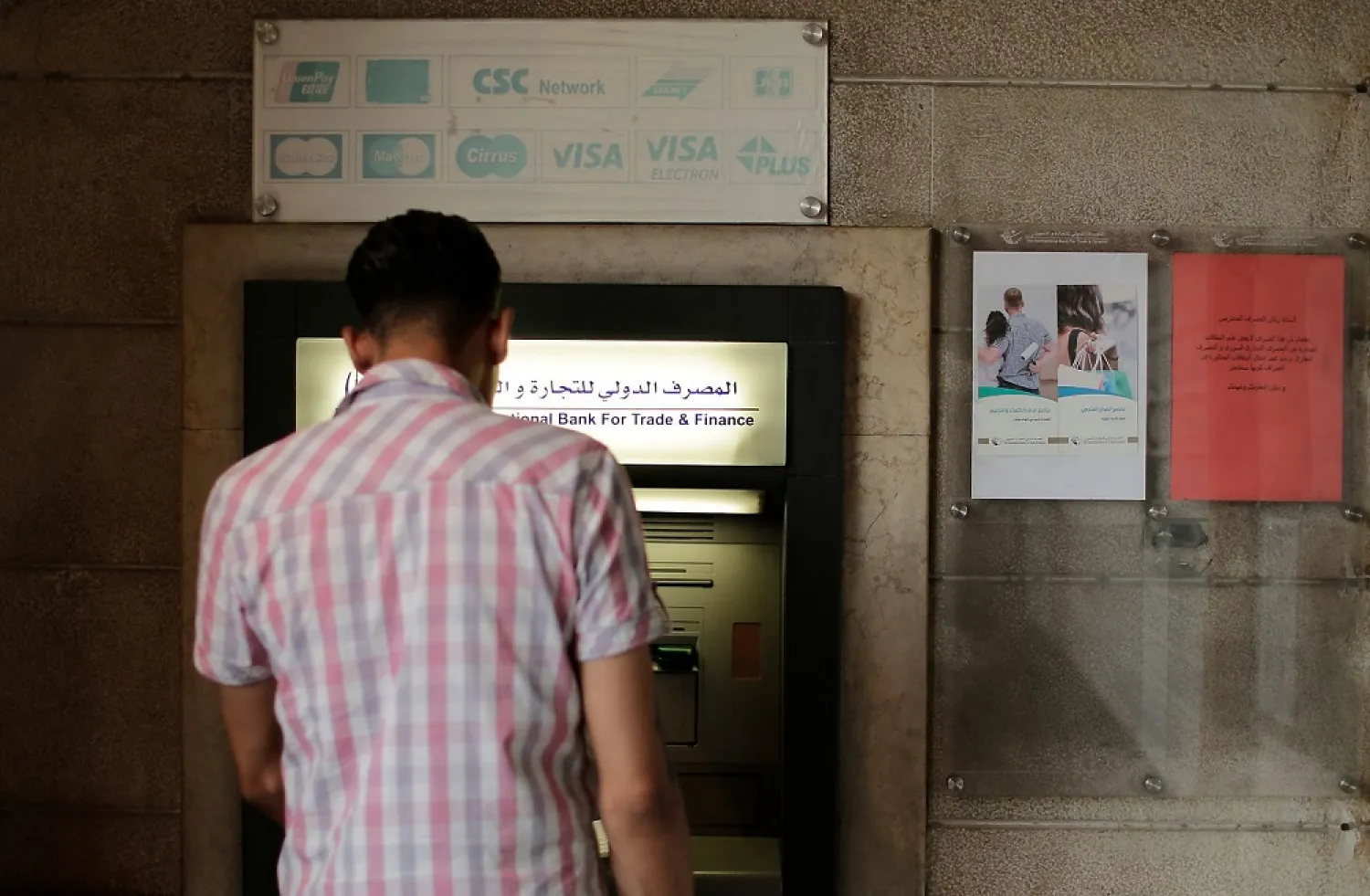 In this July 24, 2019 file photo, a man stands in front of an ATM machine outside a branch of the International Bank for Trade and Finance, in Damascus, Syria. (AP)