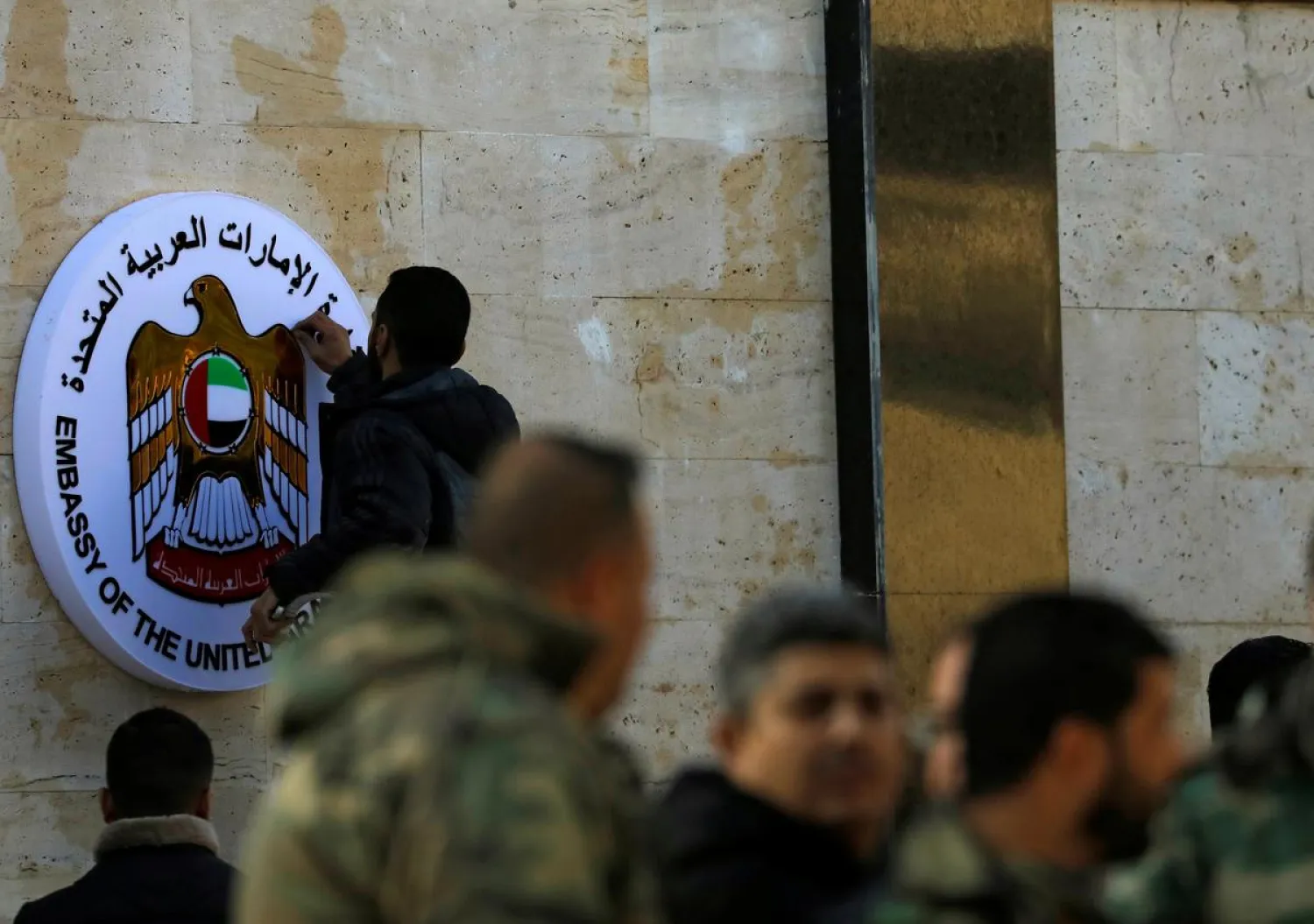 A man works on the emblem of the United Arab Emirates embassy in Damascus during its reopening, Syria December 27, 2018. (Reuters)