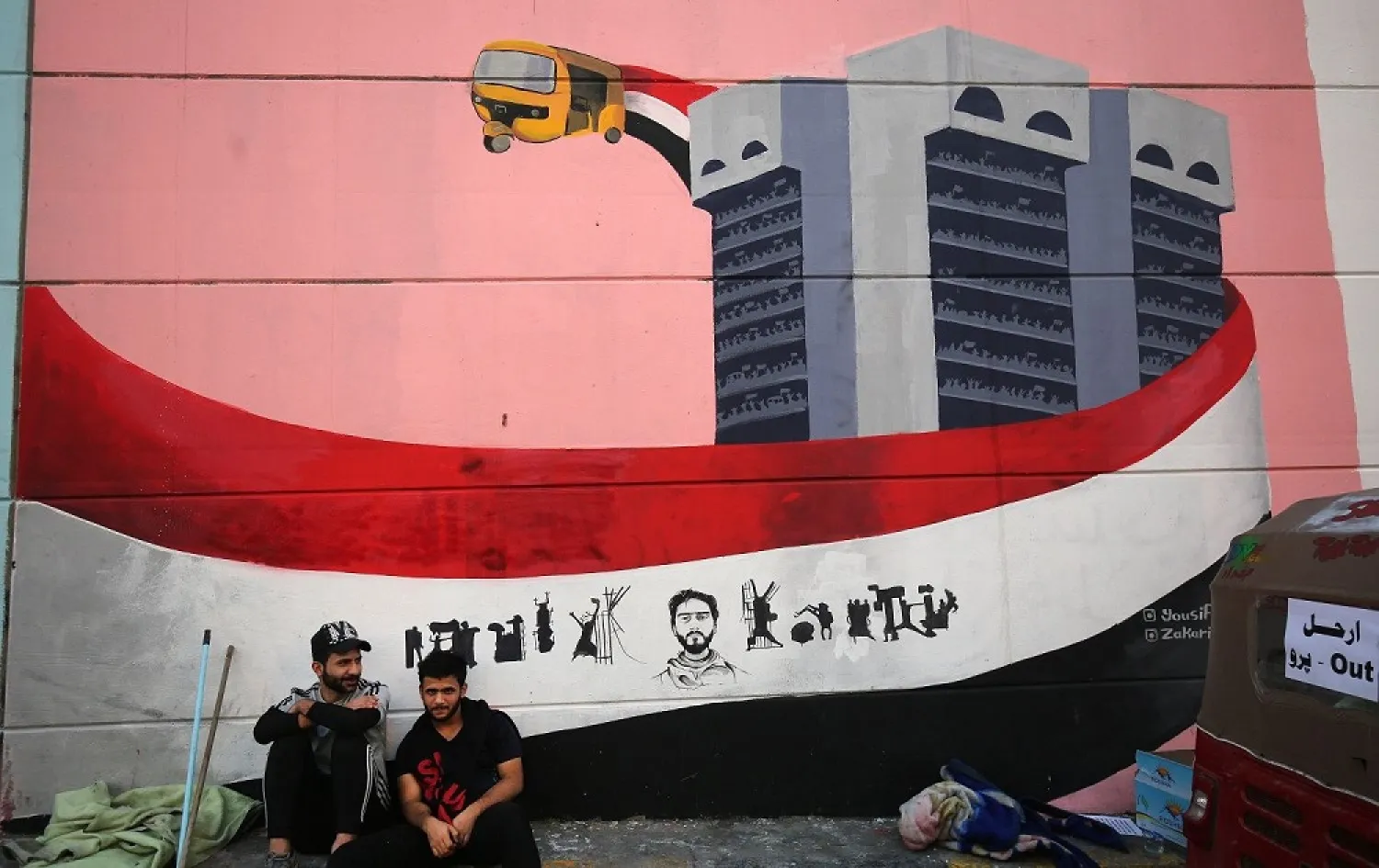 Iraqi demonstrators rest in front of a mural painting in Tahrir Square during anti-government demonstrations in Baghdad on November 8, 2019. (AFP)
