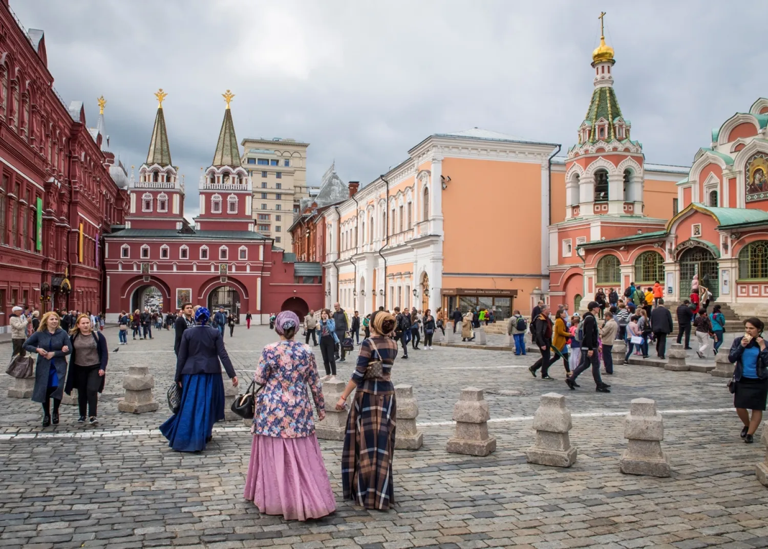 Tourists in traditional dresses walk towards Voskresenskiye Vorota (Resurrection Gates) leaving the Red Square in Moscow on July 9, 2017. (AFP)
