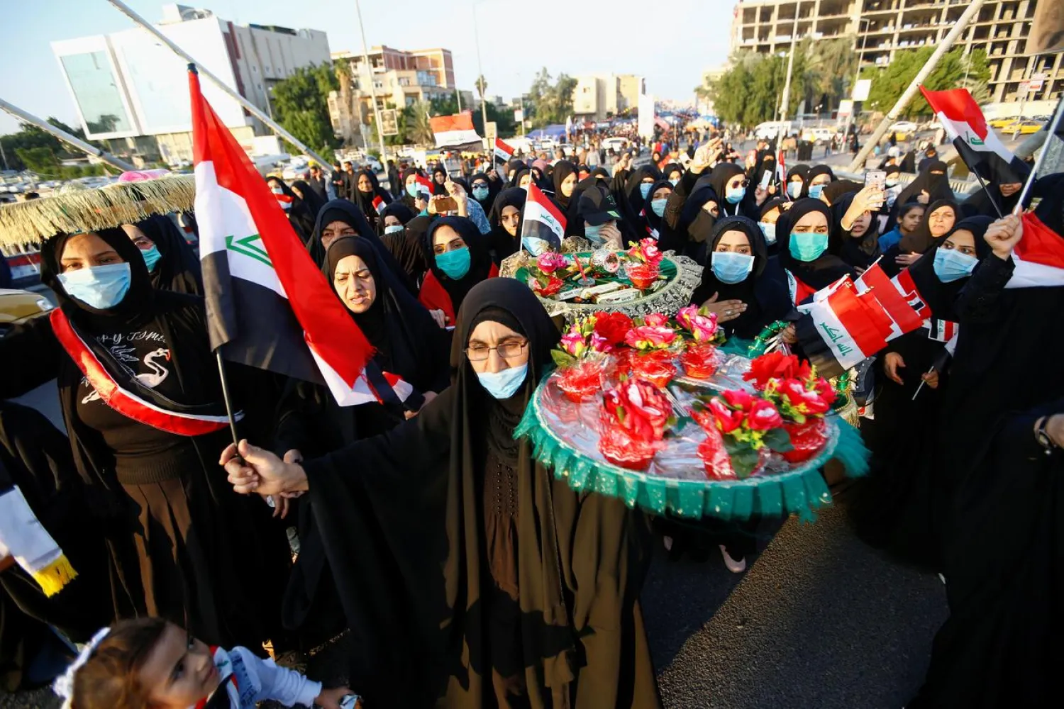 Iraqi demonstrators women carry roses on spirit of people who were killed during ongoing anti-government protests in Nassiriya, Iraq December 4, 2019. Picture taken December 4, 2019. REUTERS/Alaa al-Marjani
