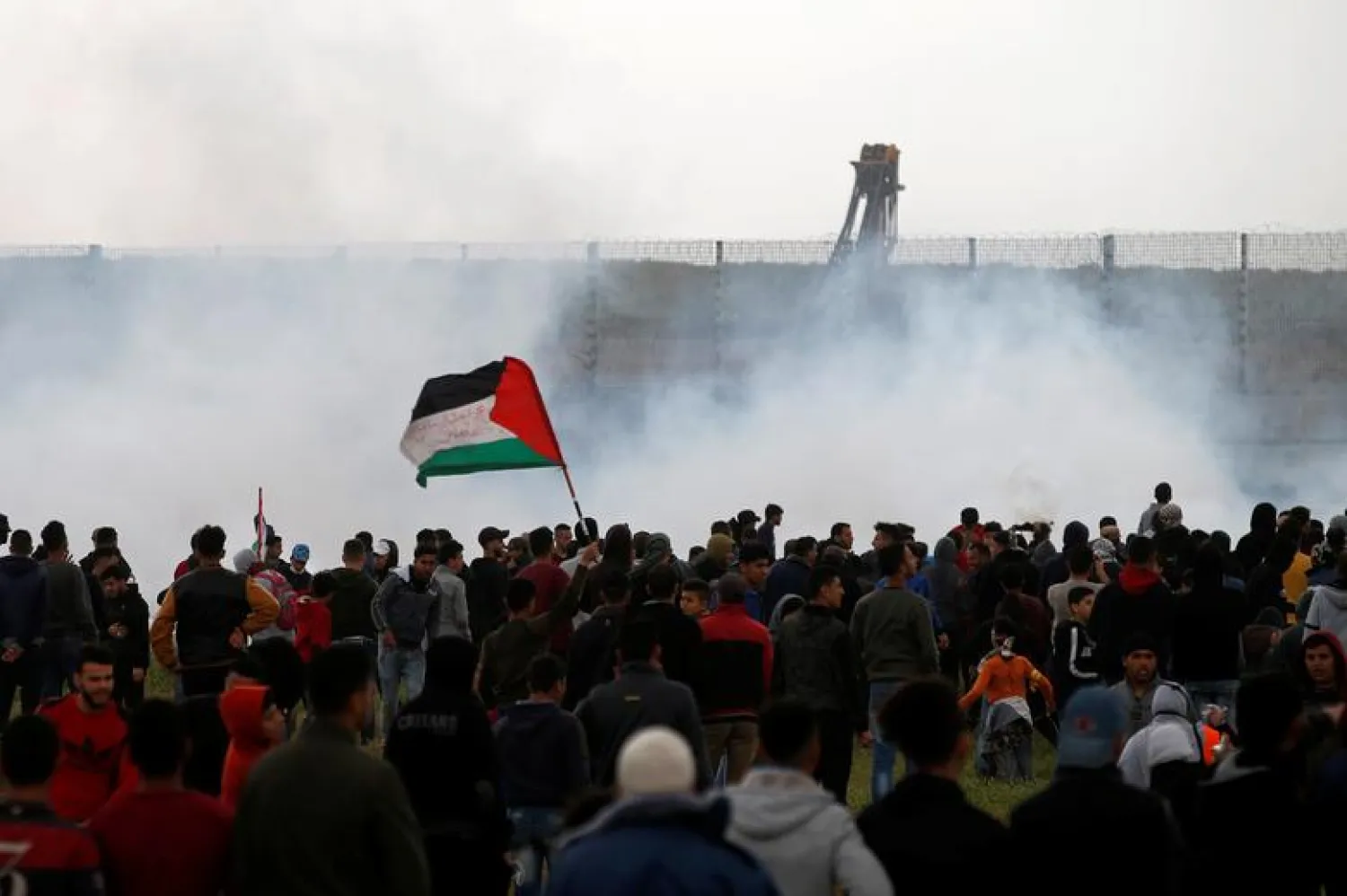 Palestinians gather as tear gas is fired by Israeli forces during a protest marking Land Day and the first anniversary of a surge of border protests, at the Israel-Gaza border fence east of Gaza City March 30, 2019. REUTERS/Mohammed Salem