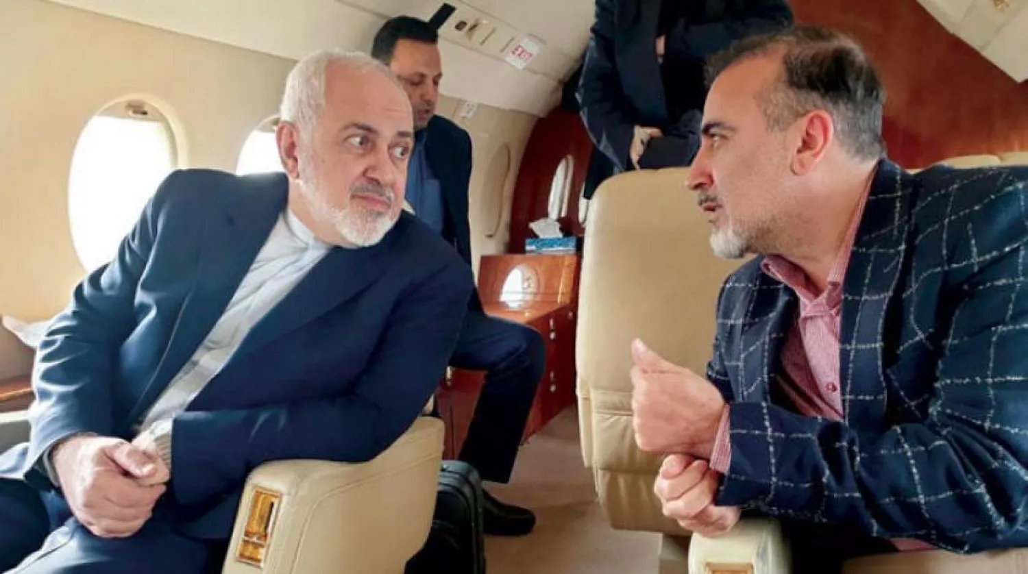 İran Dışişleri Bakanı Cevat Zarif, dün, uçakta İranlı bilim adamı Mesut Süleymani ile konuşurken (AFP)