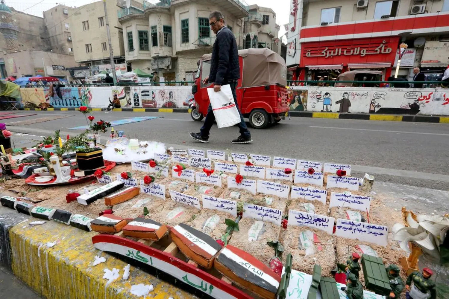 An Iraqi man walks by an installation in Tahrir Square in the capital Baghdad, in honor of protesters killed in ongoing anti-government demonstrations. (AFP)