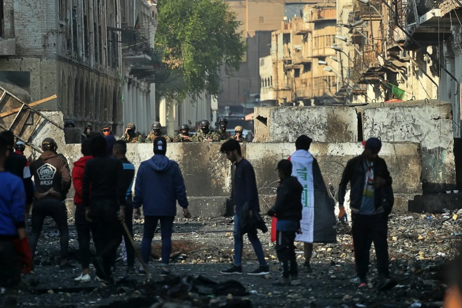 Anti-government protesters gather near barriers set up by security forces to close Rasheed Street during ongoing protests in Baghdad, Iraq, Thursday, Dec. 5, 2019. (AP)