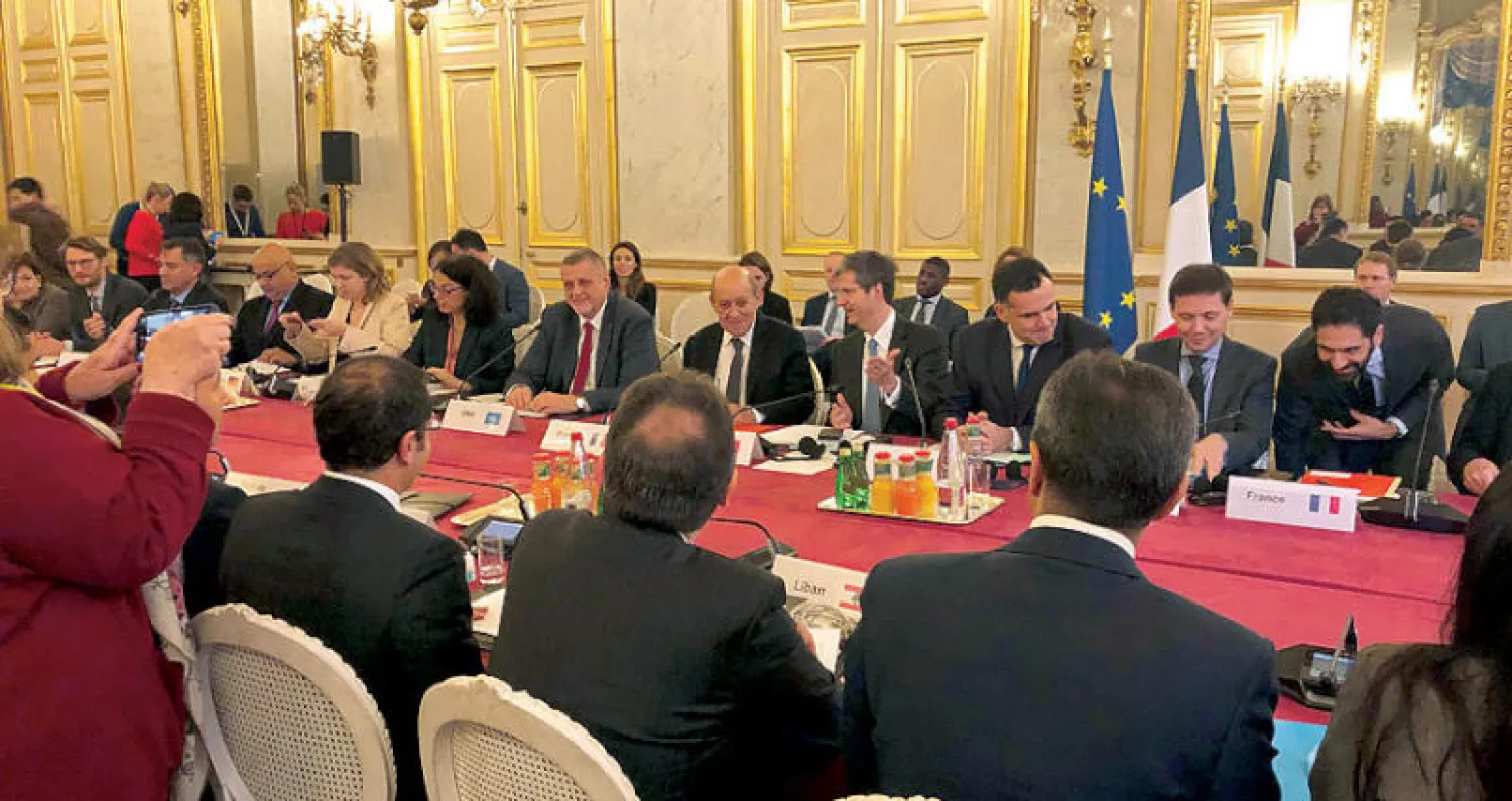 وزير الخارجية الفرنسي لودريان مع الوفود المشاركة في اجتماع باريس أمس (رويترز)