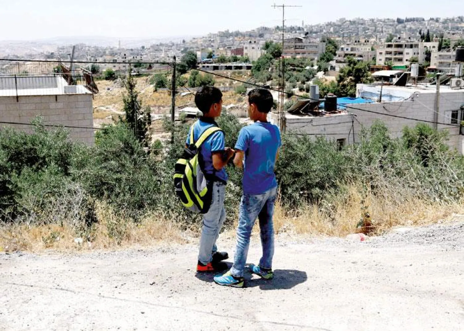Palestinian children chat outside a school in the East Jerusalem neighborhood of Jabel Mukhaber. (Reuters)

