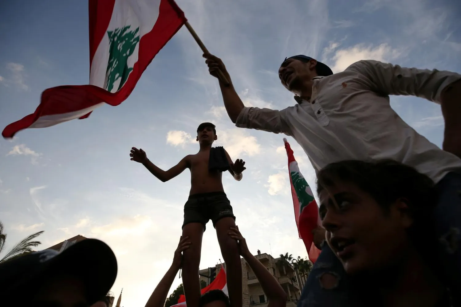 Demonstrators carry national flags and gesture during a protest targeting the government over an economic crisis in the port city of Sidon, Lebanon October 18, 2019. REUTERS/Ali Hashisho