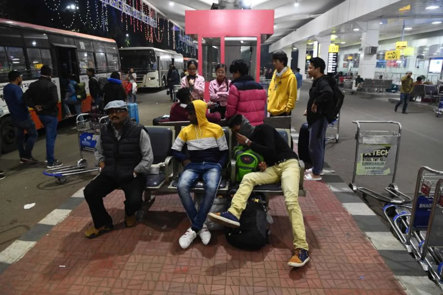 ركاب ينتظرون في مطار غواهاتي حيث ألغيت رحلات عدة بسبب الاضطرابات (أ.ف.ب)