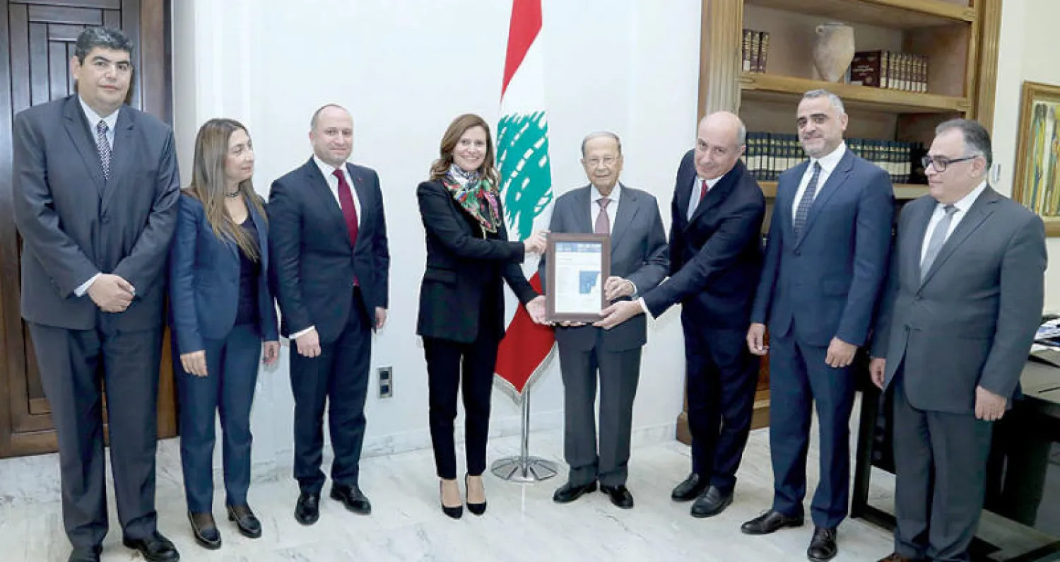 الرئيس ميشال عون يحمل نسخة من رخصة حفر بئر النفط  وإلى جانبه وزيرة الطاقة والوفد المرافق (دالاتي ونهرا)