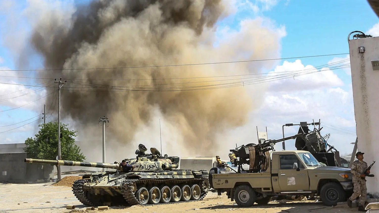 A smoke plume rising from an airstrike behind a tank belonging to forces loyal to Libya's Government of National Accord (GNA), during clashes south of the capital Tripoli (File photo: AFP)