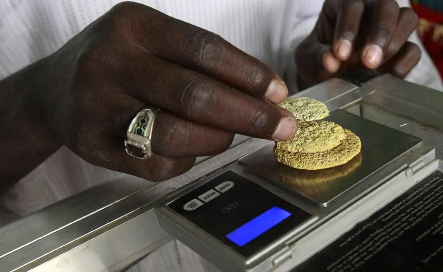 Gold mine workers weigh their gold in River Nile State, July 30, 2013. (Reuters)