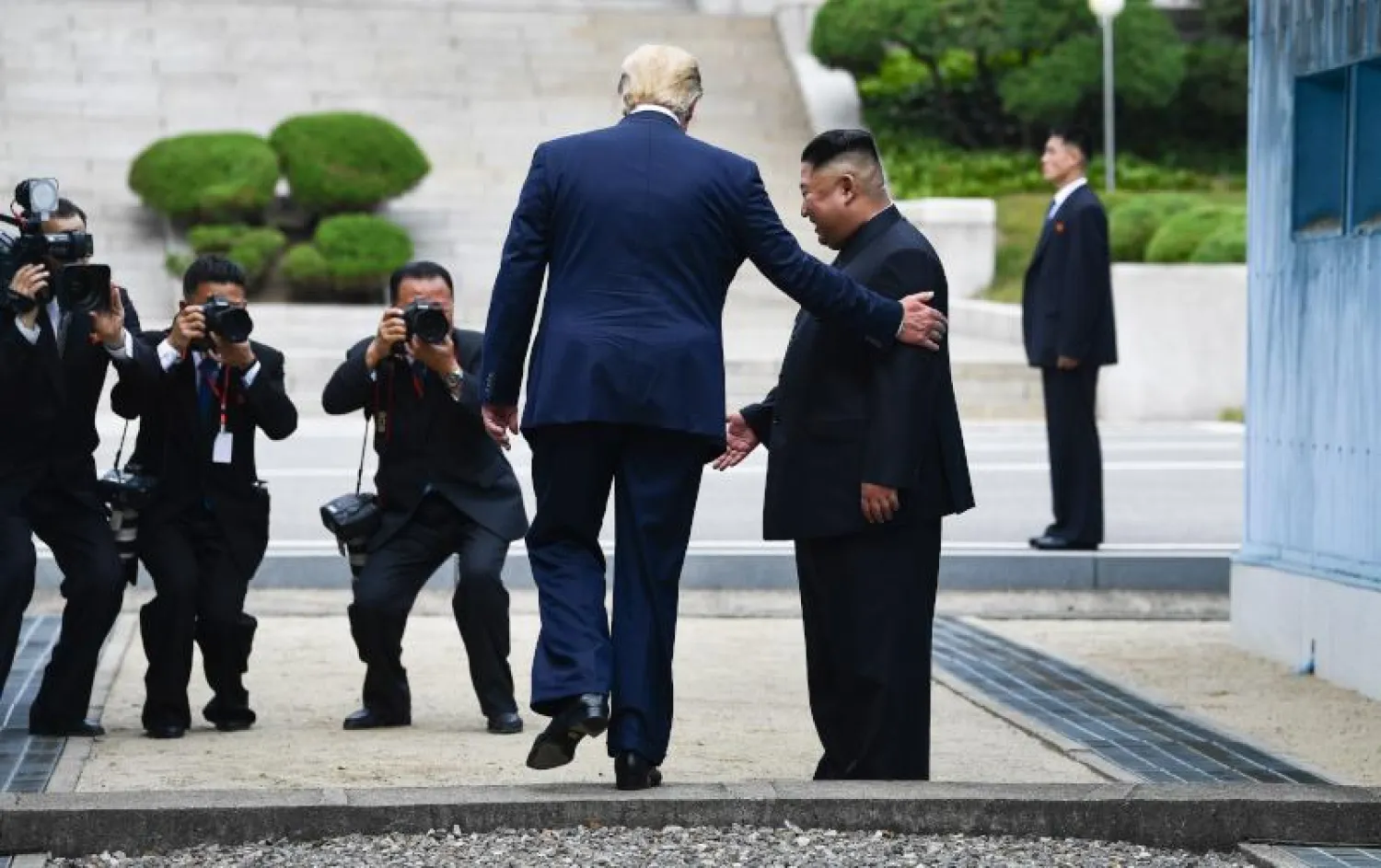 الرئيس الأميركي دونالد ترمب يعبر المنطقة المنزوعة السلاح بين الكوريتين إلى كوريا الشمالية للقاء كيم جونغ أون في يونيو الماضي (أ.ف.ب)
