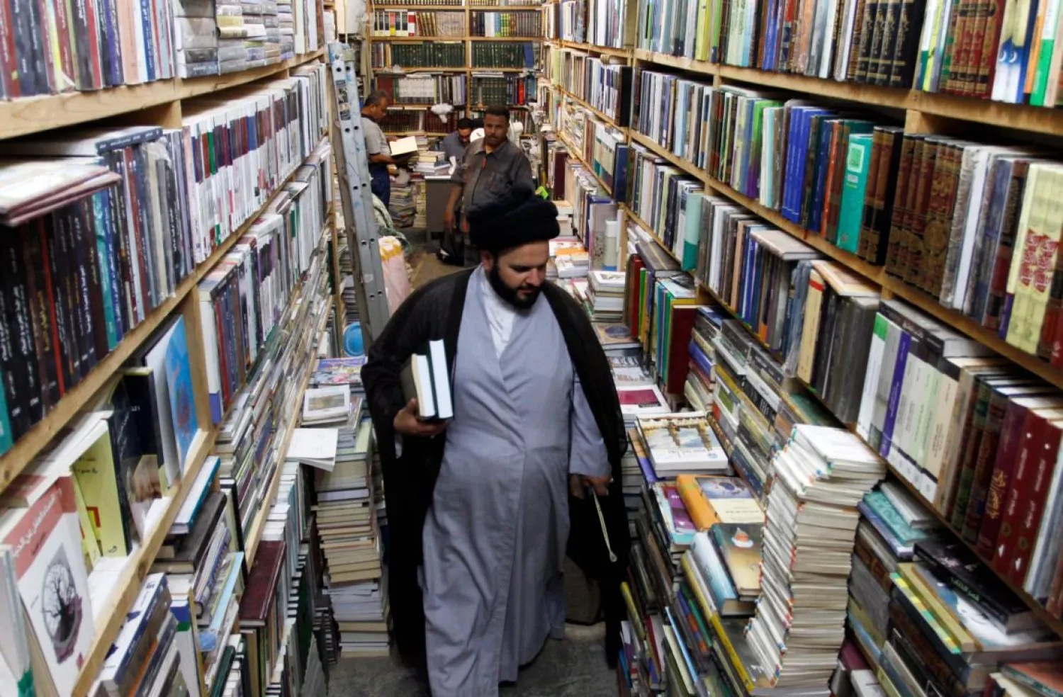 A Muslim cleric walks among books shelves at the Howeish book market in Najaf. (AFP)