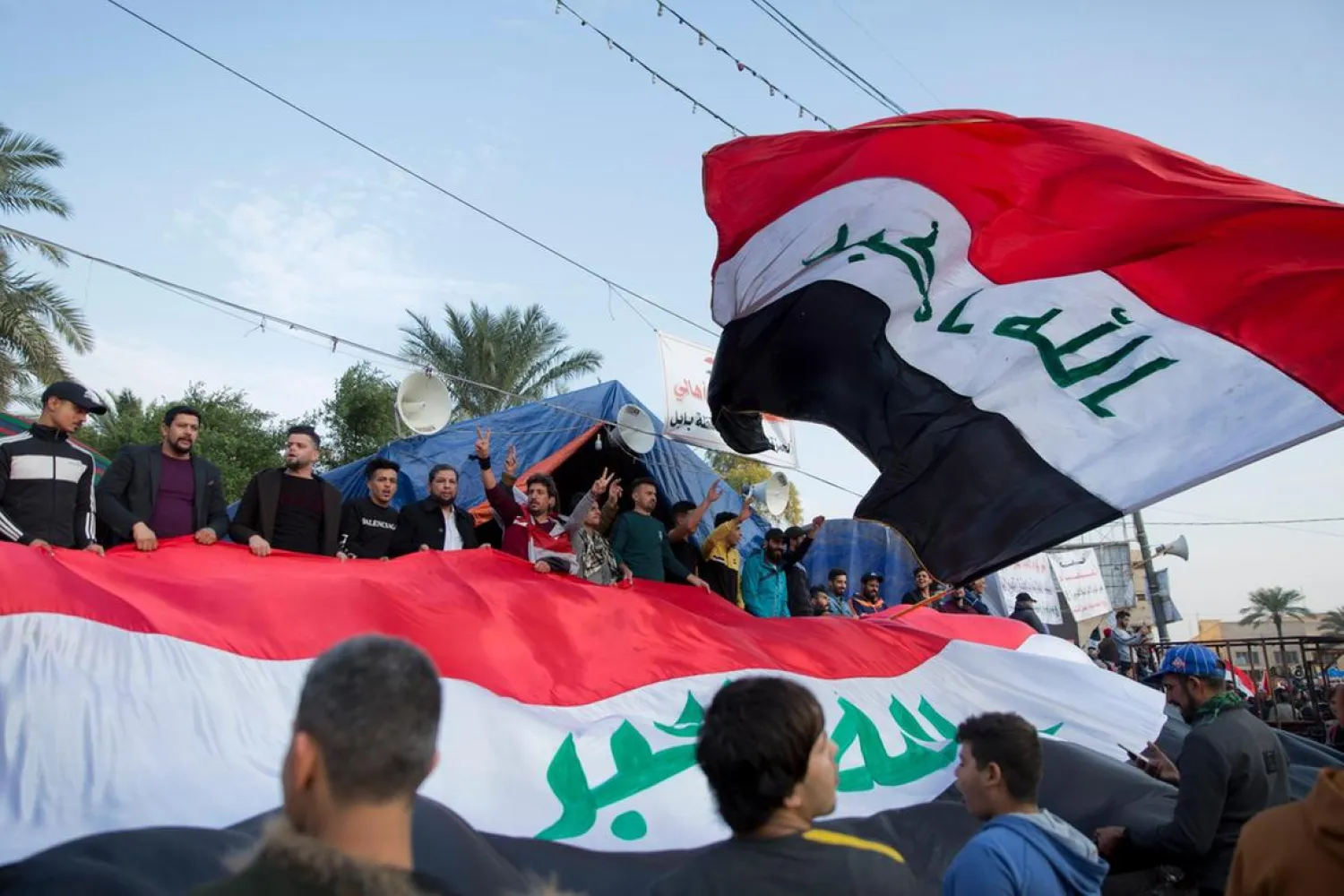 Activists chant anti-government slogans and fly big Iraqi flags at Tahrir Square in Baghdad, Iraq. (AP)