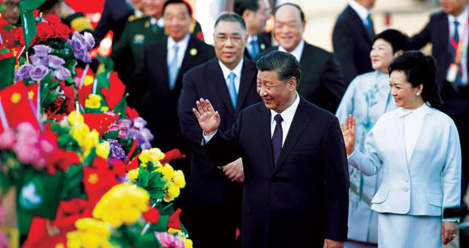 شي جينبينغ وزوجته لدى وصولهما إلى ماكاو أمس (أ.ب)