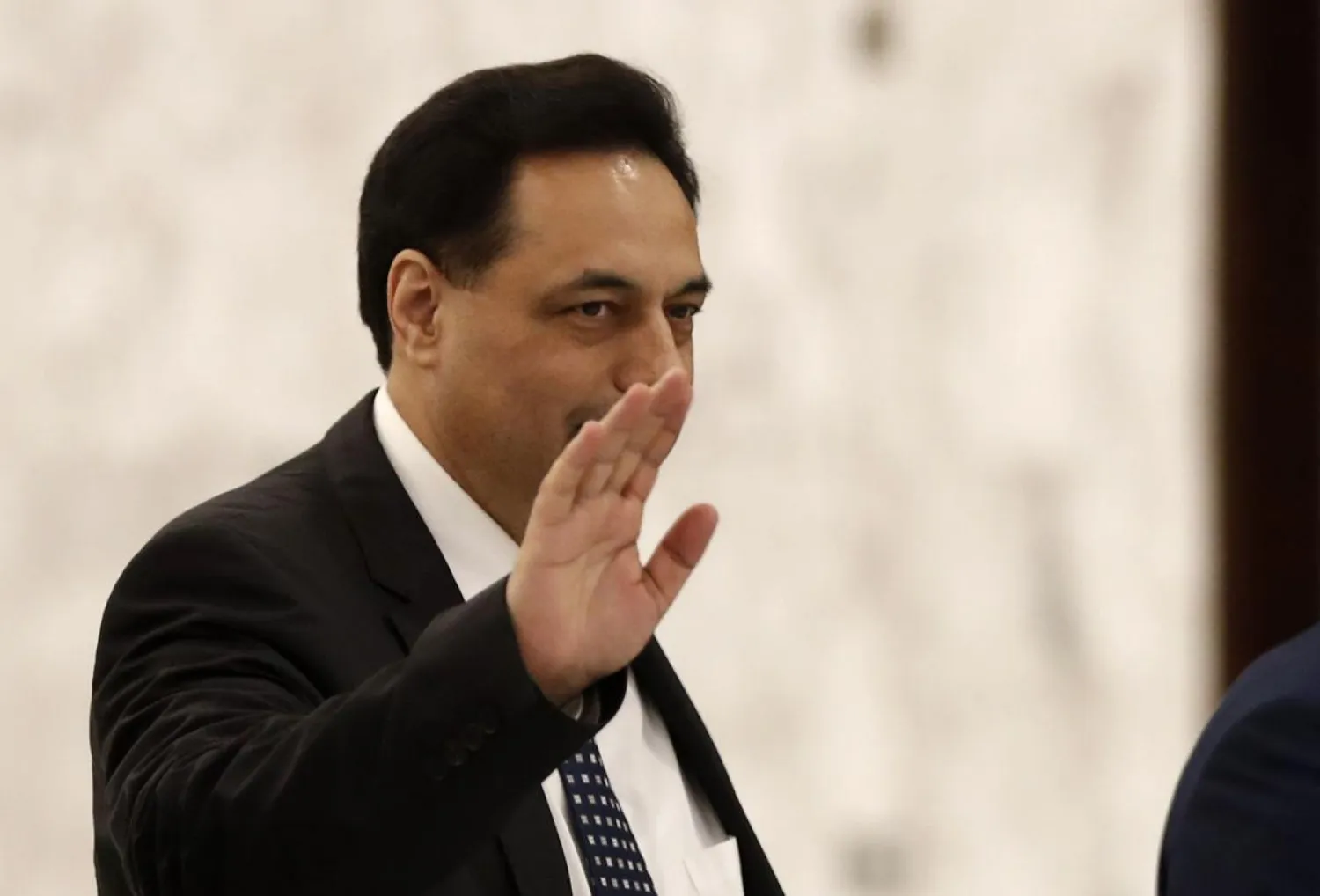 Newly-assigned Lebanese Prime Minister, Hassan Diab, waves to journalists upon his arrival to meet with Lebanese President Michel Aoun at the presidential palace, in Baabda, east of Beirut, Lebanon, Thursday, Dec. 19, 2019. (AP Photo/Hussein Malla)