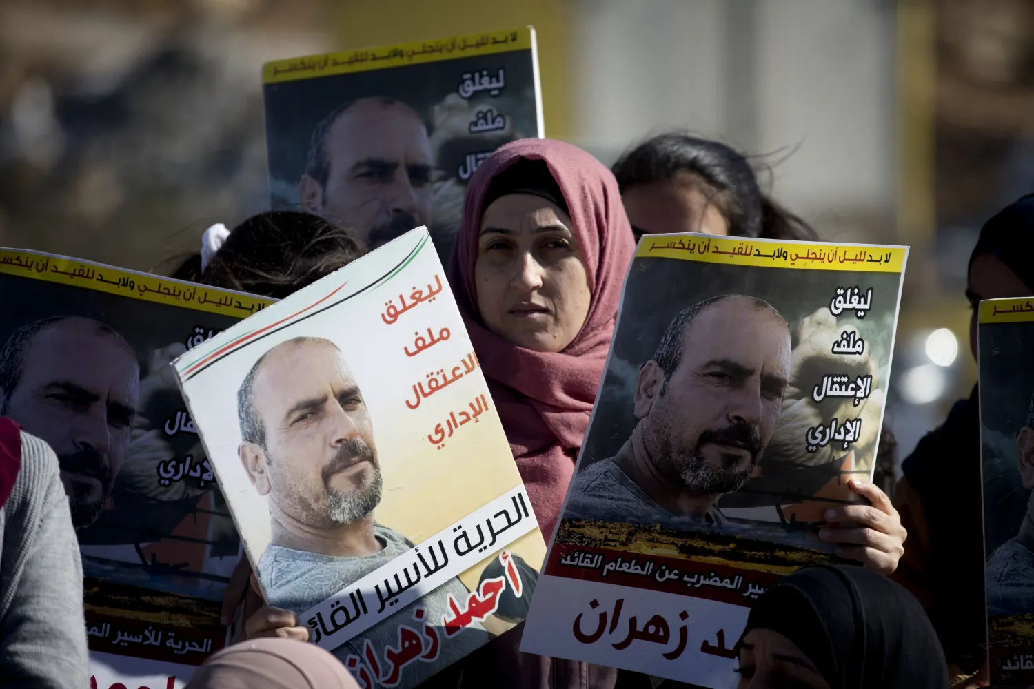 Karemah Zahran holds photograph of her husband Ahmed Zahran , who has been on a partial hunger strike for nearly three months, outside Ofer military prison near the West Bank city of Ramallah, Thursday, Dec. 19, 2019. (AP Photo/Majdi Mohammed)