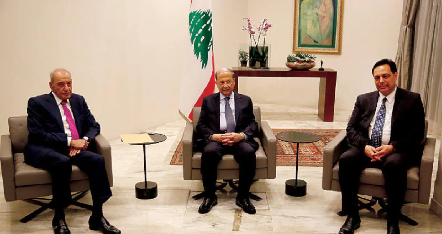 الرئيس ميشال عون لدى استقباله رئيس الحكومة المكلف حسان دياب في حضور رئيس البرلمان نبيه بري (أ.ب)