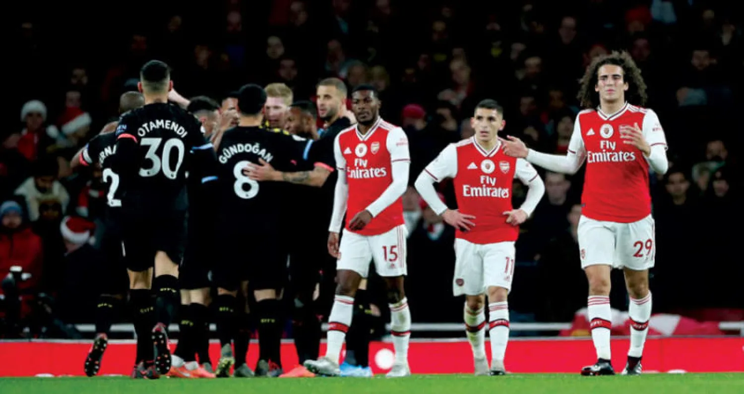 لاعبو ارسنال يراقبون في حسرة احتفالات لاعبي سيتي بالفوز عليهم (رويترز)