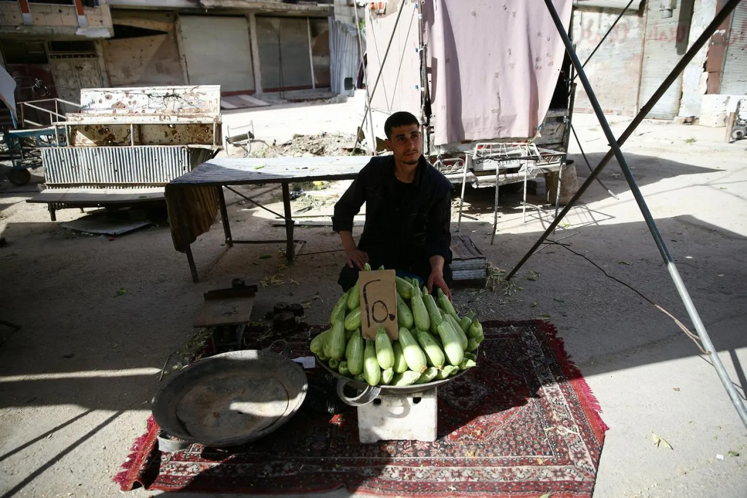 A man sells zucchini for 250 Syrian pounds a kilo in the city of Douma, in the eastern Damascus suburb of Ghouta, Syria May 10, 2017. (Reuters)