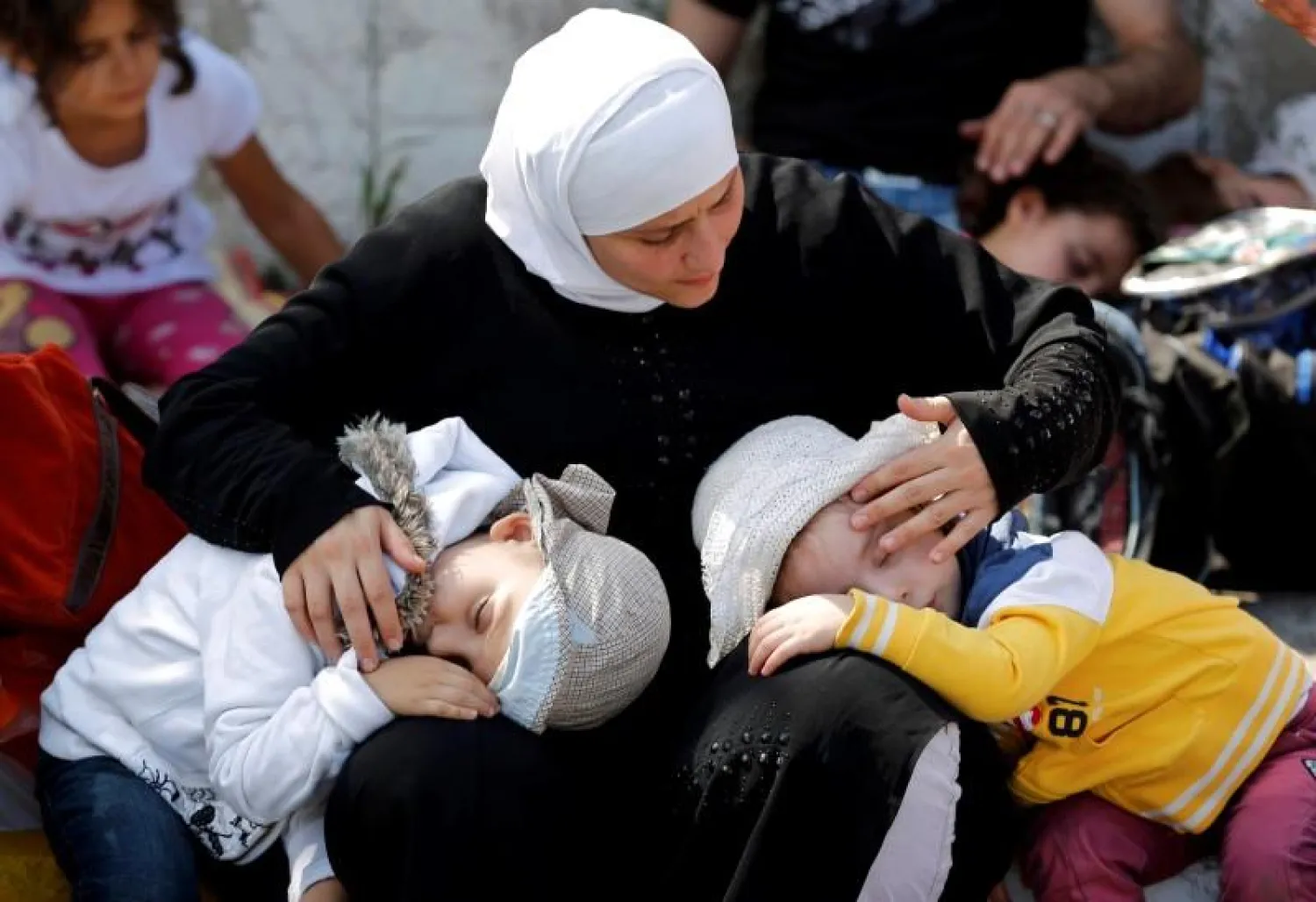 Children sleep on a migrant woman's lap as they wait at the main bus station in Istanbul, Turkey, September 15, 2015. REUTERS/Murad Sezer
