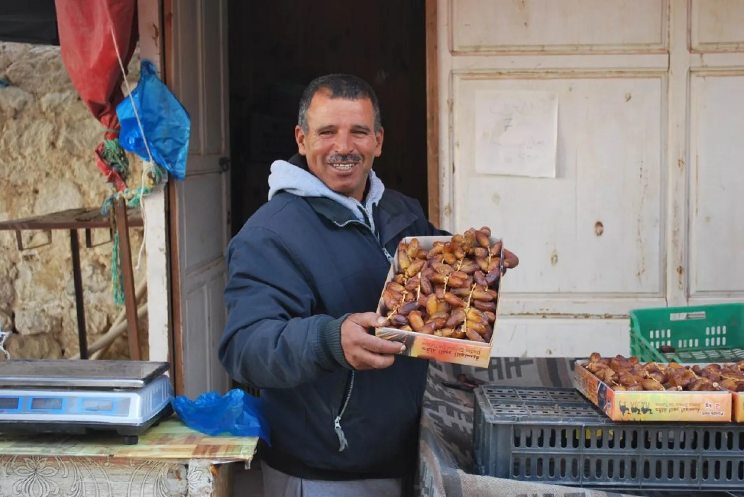 Lazhar Ghiloufi, a date seller in Kebili, south Tunisia, holds up a box of good quality deglet nour dates, December 2, 2019. (Thomson Reuters Foundation)