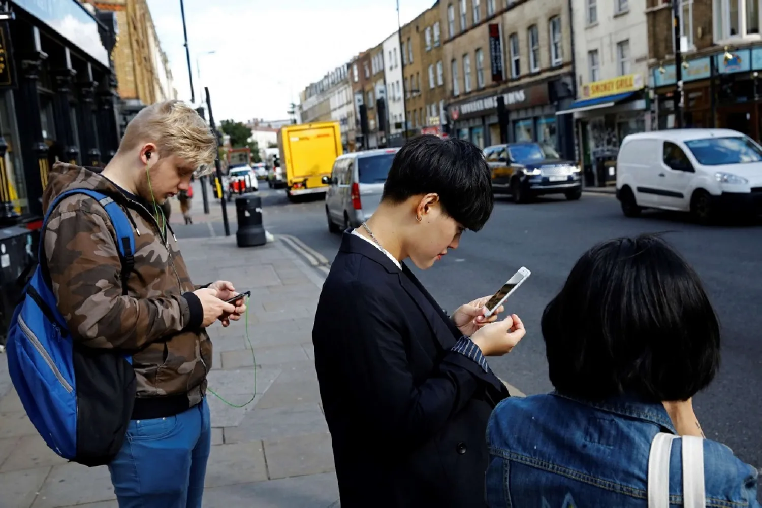 Pedestrians in London looking at their smartphones. (Reuters)