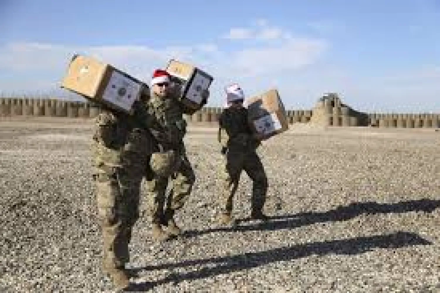In this Monday, Dec. 23, 2019, photo, US soldiers deliver Christmas gifts to their comrades on a base near the al-Omar oilfield in eastern Syria. It's an operation is called Holiday Express - in addition to delivering presents, the US-led coalition forces brought a US military band to play Christmas carols and music to several bases in eastern Syria. (AP Photo/Farid Abdul-Wahid)