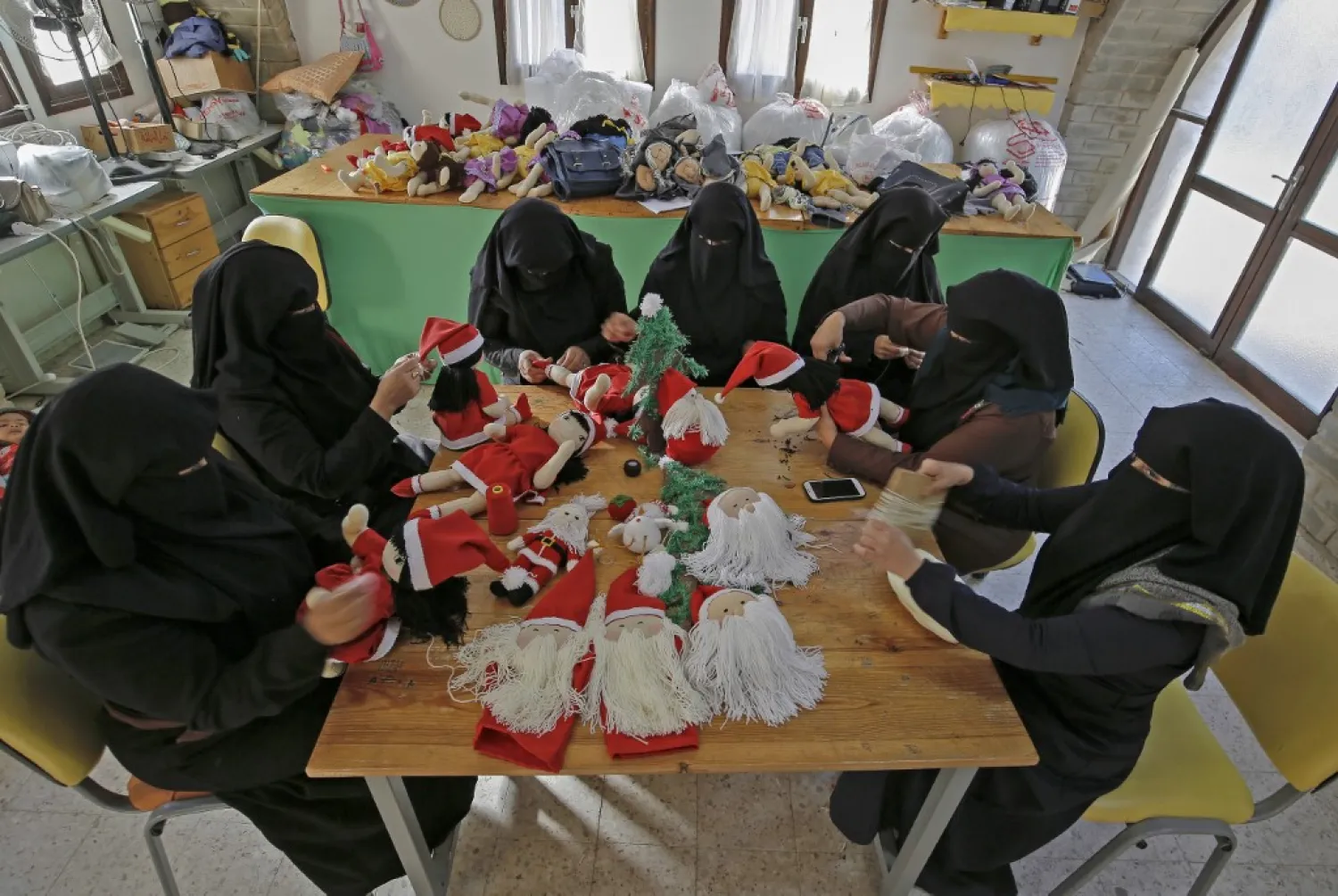 Some 20 young women are employed at the Zeina Cooperative factory in the Palestinian village of Umm al-Nasser, where they have been given three years of vocational training, learning to make gifts for a series of holidays | AFP