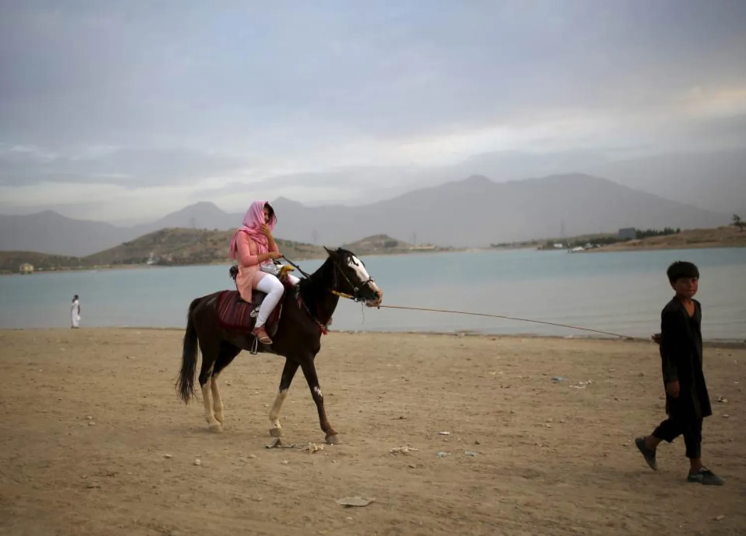 A woman enjoys a horse ride along Qargha lake, in Kabul, Afghanistan July 21, 2015. REUTERS/Ahmad Masood