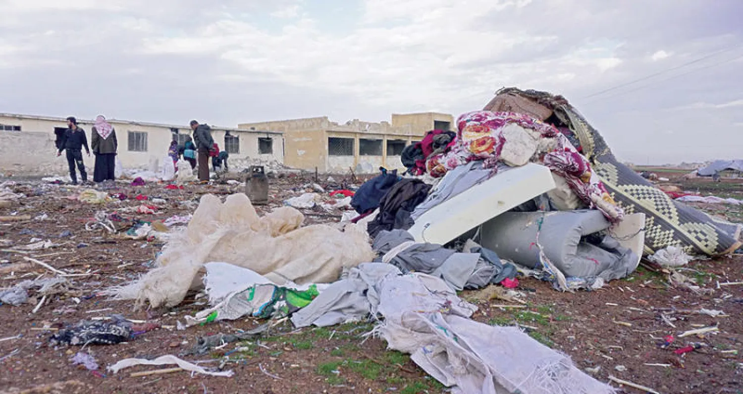 سكان سراقب شمال غربي سوريا يتفقدون الدمار الذي لحق بقرية جوباس بعد مقتل 8 على الأقل (أ.ف.ب)