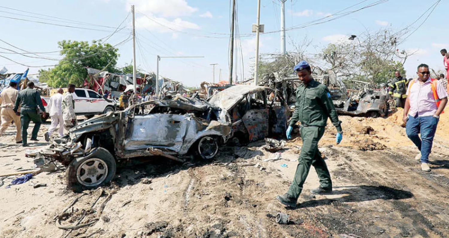 ضابط صومالي يعاين موقع تفجير الشاحنة الملغومة في تقاطع مكتظ بالمواطنين بالعاصمة مقديشيو أمس (رويترز)