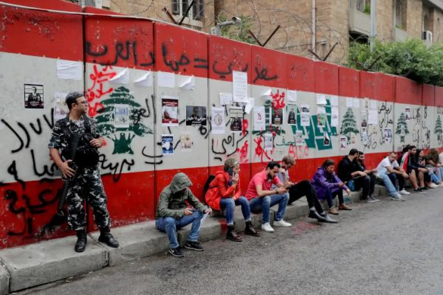 Lebanese protesters sit along a road in front of the Lebanese Central Bank as they block a street during ongoing anti-government demonstrations in the capital Beirut on October 28, 2019. AFP