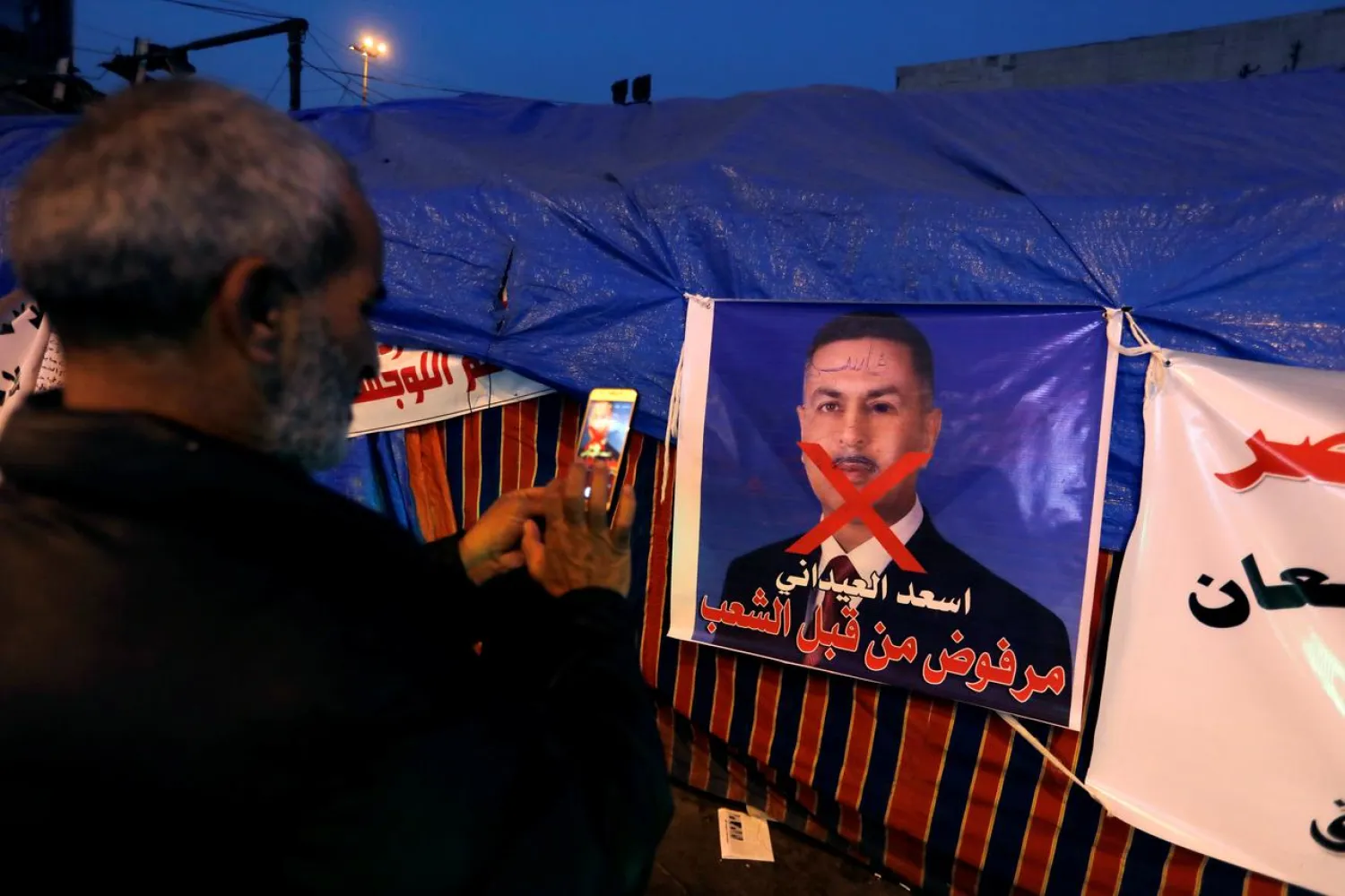 A poster of Asaad al-Edani, Basra governor and a candidate for the prime minister office during ongoing anti-government protests in Baghdad (Reuters)