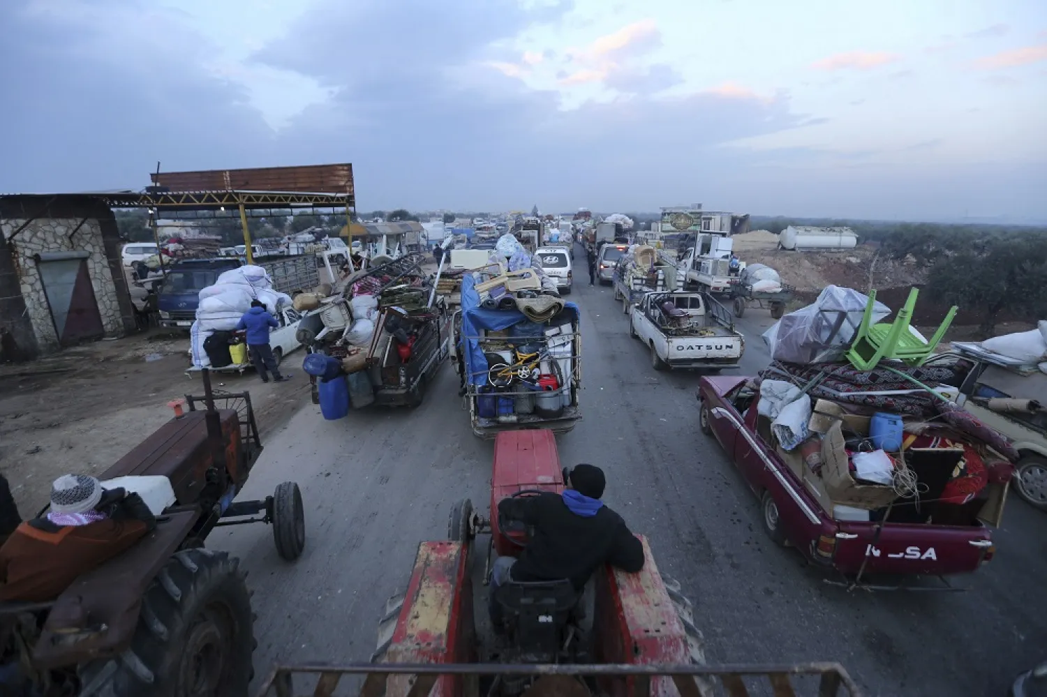 Truckloads of civilians flee a Syrian military offensive in Idlib province on the main road near Hazano, Syria, Tuesday, Dec. 24, 2019. (AP)